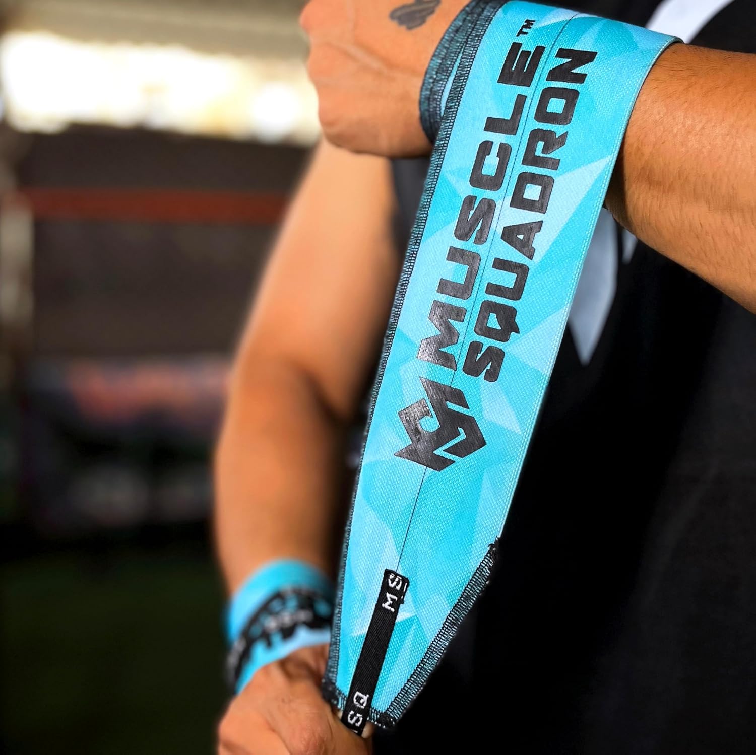 Close-up of a man's wrist, showing Gripzora's Blue Streak wrist wraps providing firm stability and support during a workout.