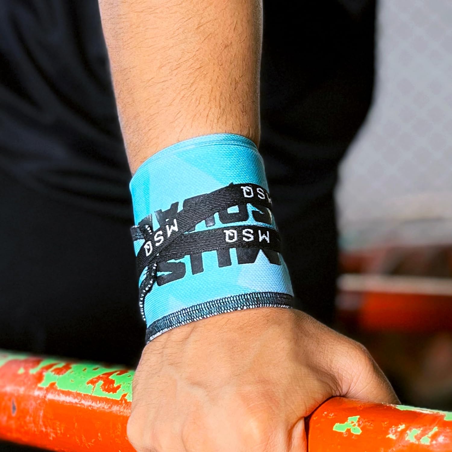 Close-up of a hand wearing Gripzora Blue Streak wrist wraps, providing crucial stability and support during heavy lifts and calisthenics training.