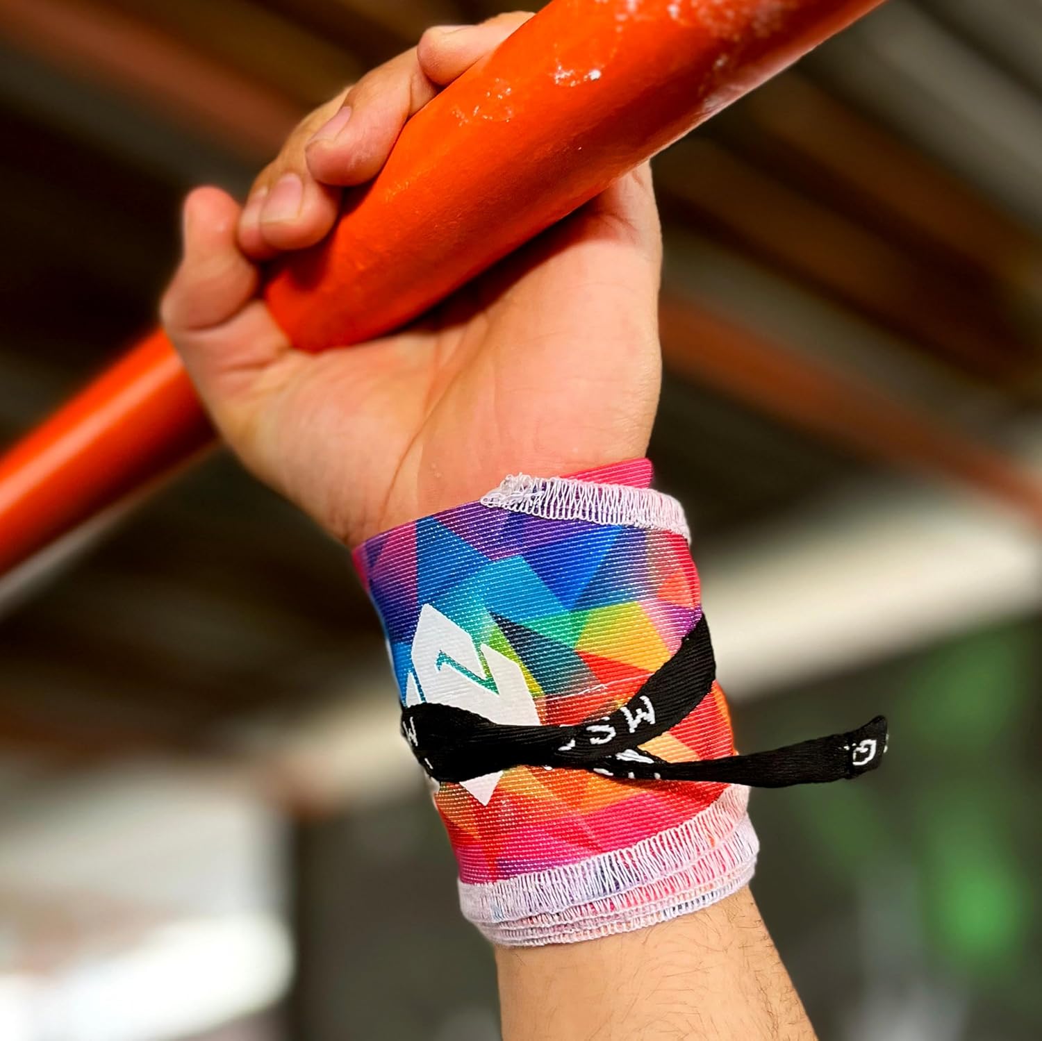 Close-up of a hand gripping a pull-up bar, wearing Gripzora Chromatic Burst wrist wraps for enhanced stability during calisthenics and weightlifting.