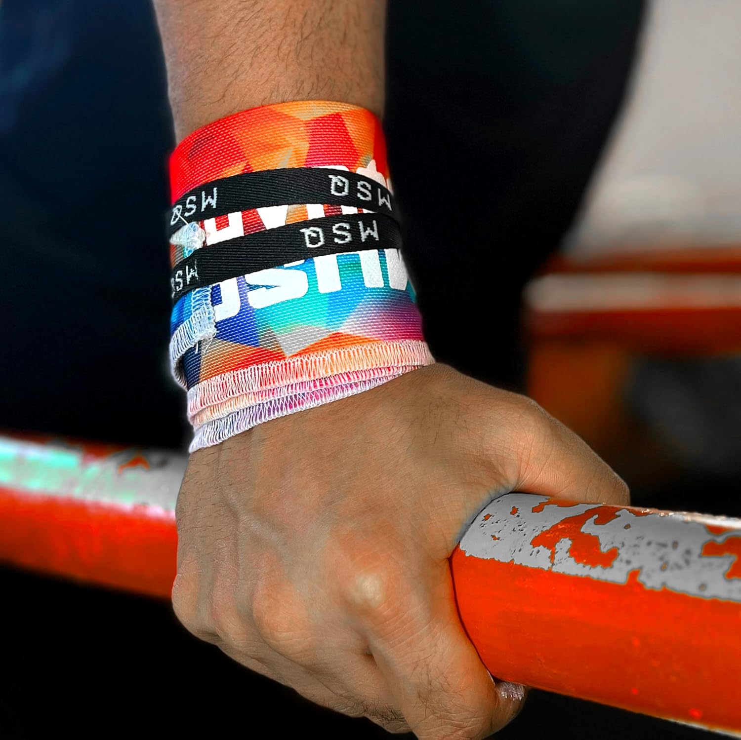 Close-up of a hand gripping a pull-up bar, wearing Gripzora Chromatic Burst calisthenics wrist wraps for enhanced stability and injury prevention.