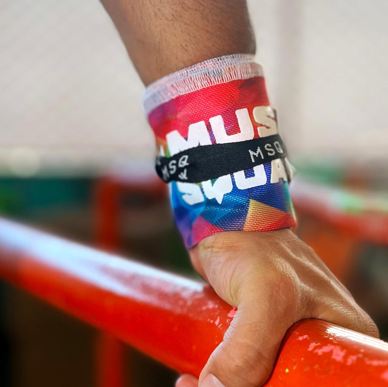 Close-up of a hand wearing Gripzora Chromatic Burst wrist wraps, providing crucial stability and support during heavy lifts and calisthenics training.