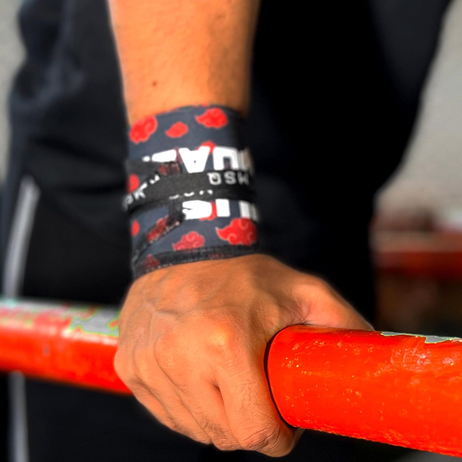 Close-up of a hand gripping a pull-up bar, wearing Gripzora Crimson Cloud calisthenics wrist wraps for enhanced stability and injury prevention.