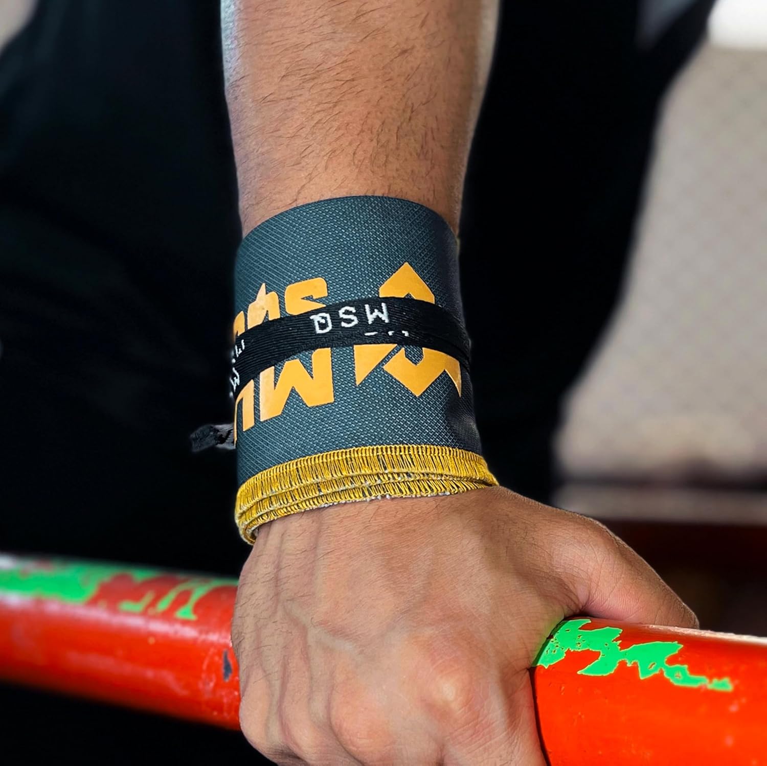 Close-up of a hand gripping a pull-up bar, wearing Gripzora Urban Grime calisthenics wrist wraps for enhanced stability and injury prevention.