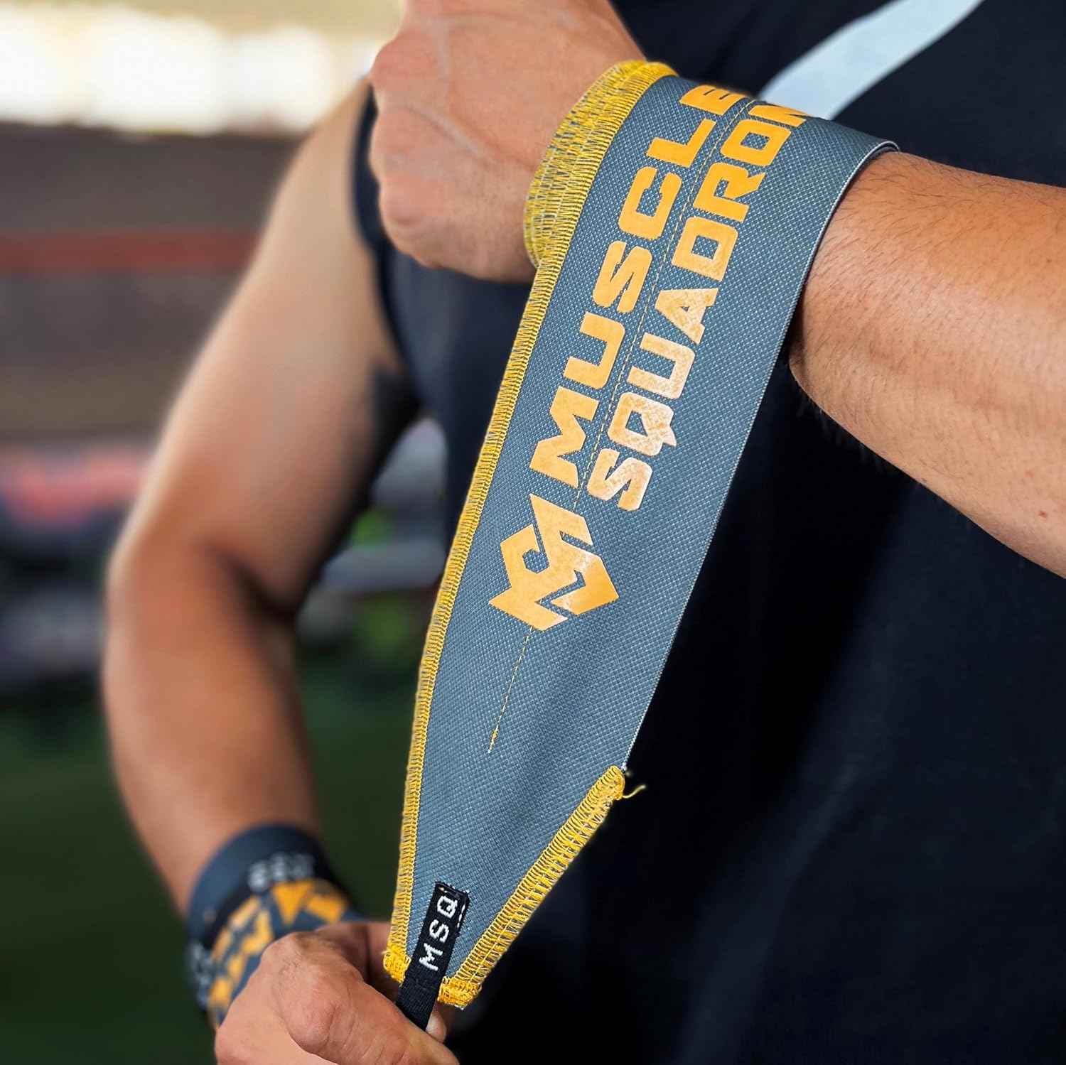 Close-up of a man's wrist, showing Gripzora's Urban Grime wrist wraps providing firm stability and support during a workout.
