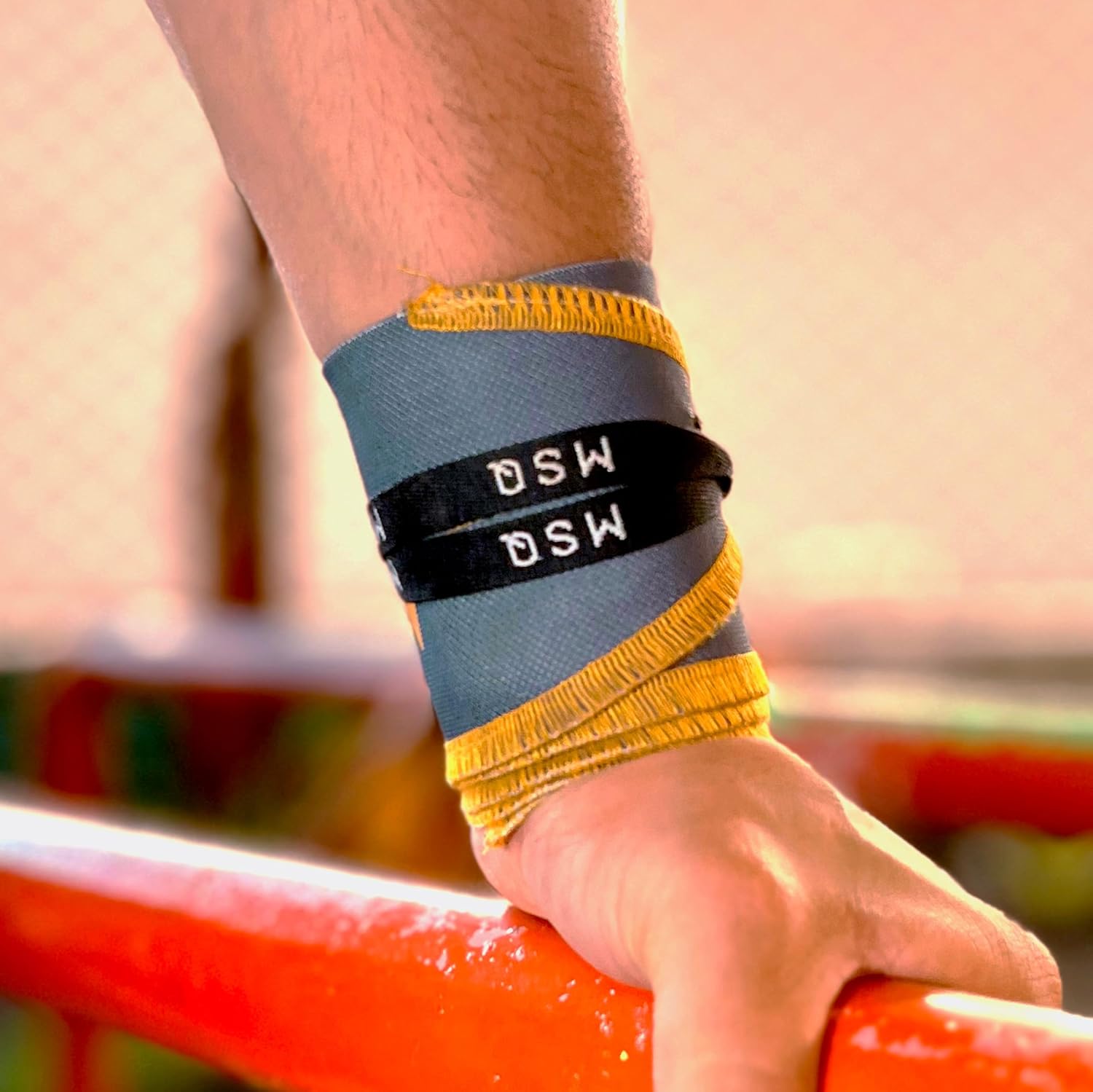 Close-up of a hand wearing Gripzora Urban Grime wrist wraps, providing crucial stability and support during heavy lifts and calisthenics training.