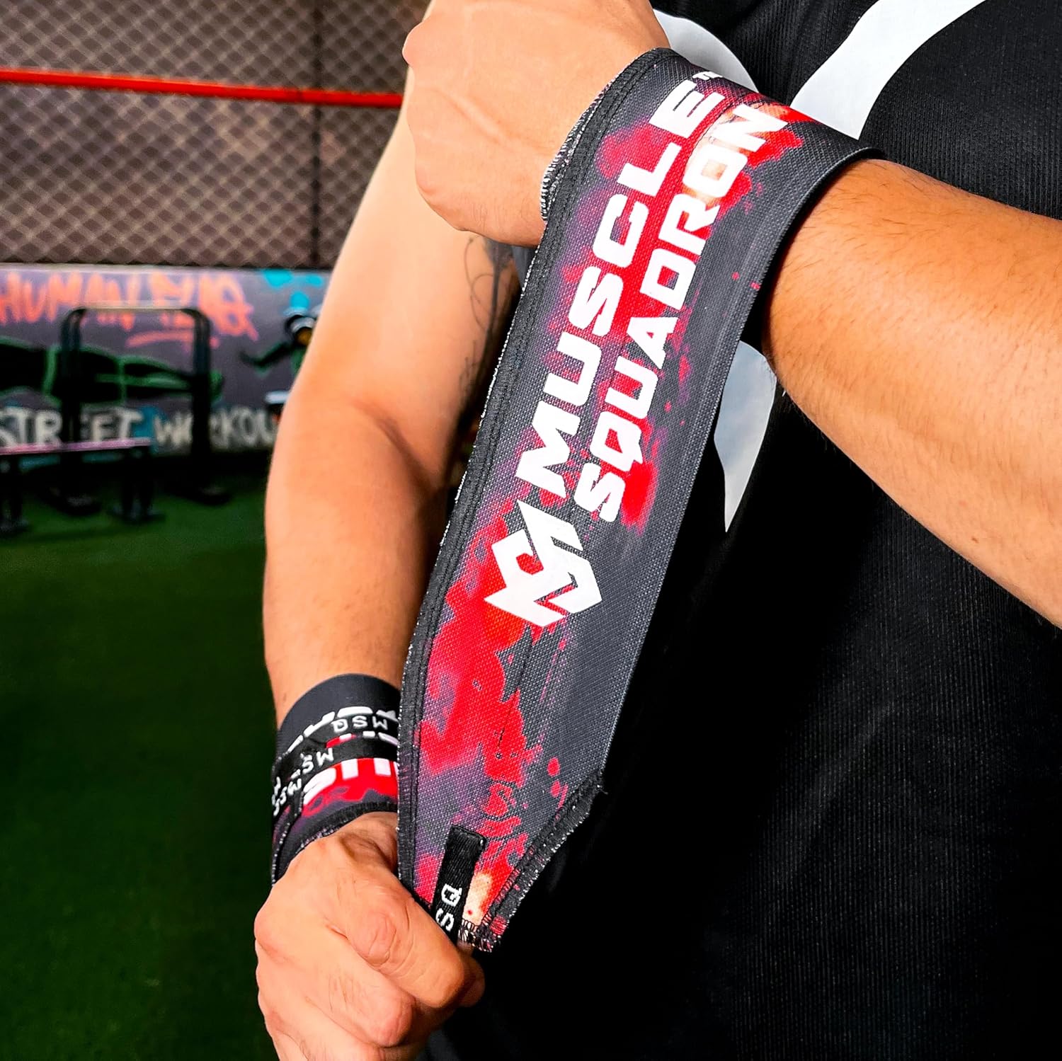 Close-up of a man's wrist, showing Gripzora's Crimson Wave wrist wraps providing firm stability and support during a workout.