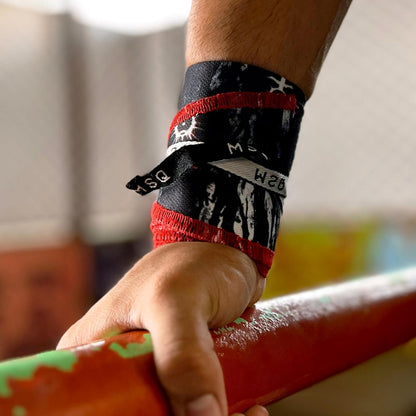 Close-up of a hand wearing Gripzora Lunar Phase wrist wraps, providing crucial stability and support during heavy lifts and calisthenics training.