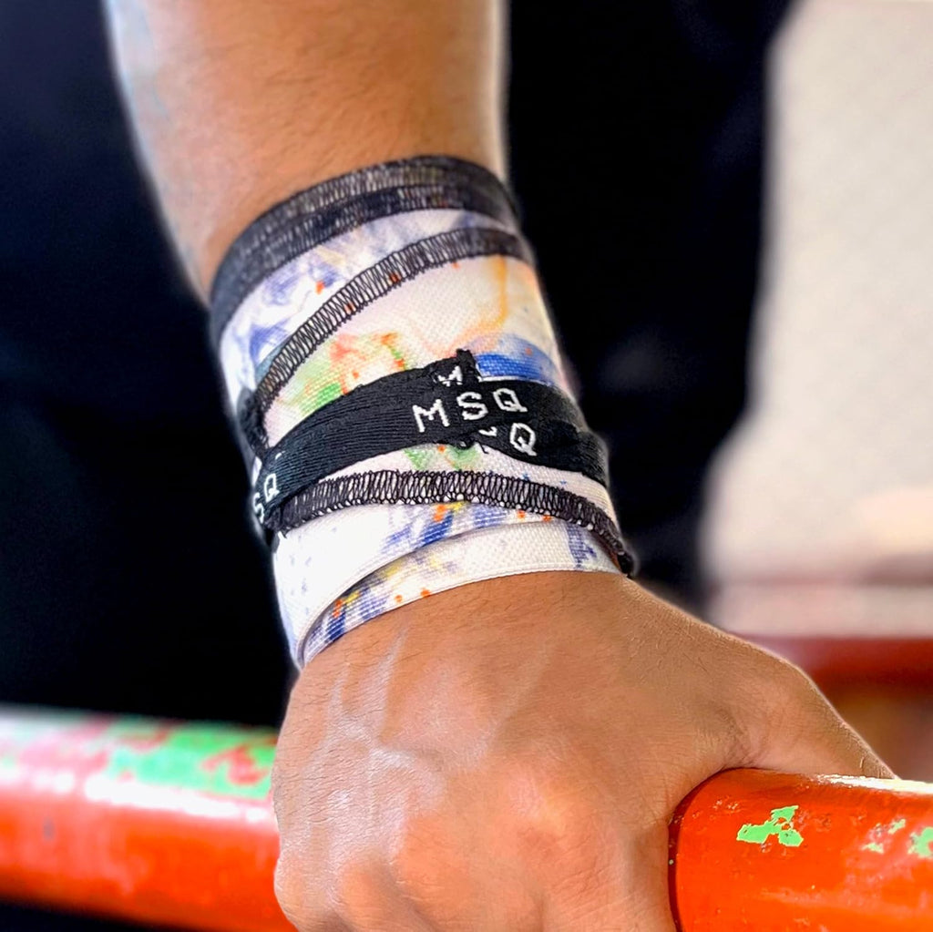 Close-up of a hand gripping a pull-up bar, wearing Gripzora Galaxy Bloom calisthenics wrist wraps for enhanced stability and injury prevention.